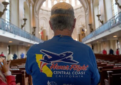 "Back view of a veteran standing at the back of the Naval Academy Chapel in Annapolis, looking down the long aisle, deep in reflection."