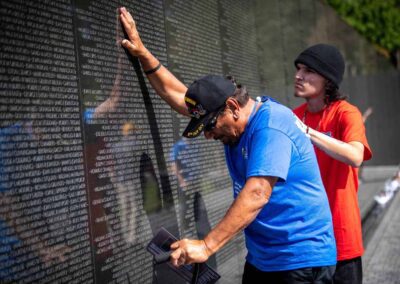 Veteran touching the names on the Vietnam Veterans Memorial Wall in Washington, D.C.