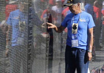 Veteran standing in reflection at the Vietnam Veterans Memorial Wall in Washington, D.C.